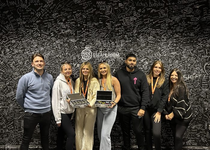 Group of colleagues posing after completing an escape room challenge at The Escape Room Guys in Derby