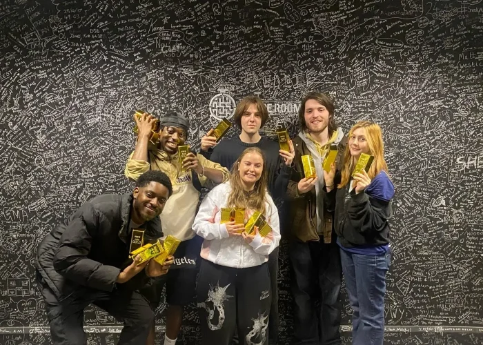 Winning team posing after finishing The Grand Heist escape room challenge at The Escape Room Guys in Derby